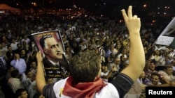A protester holds up a poster with an image of former Egypt president Gamal Abdel Nasser during the anniversary of the 1952 Egyptian revolution at Tahrir Square in Cairo, July 23, 2012. 