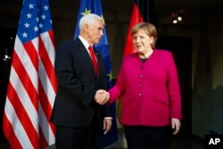 German Chancellor Angela Merkel, right, welcomes United States Vice President Mike Pence, left, for a bilateral meeting during the Munich Security Conference in Munich, Germany, Saturday, Feb. 16, 2019.