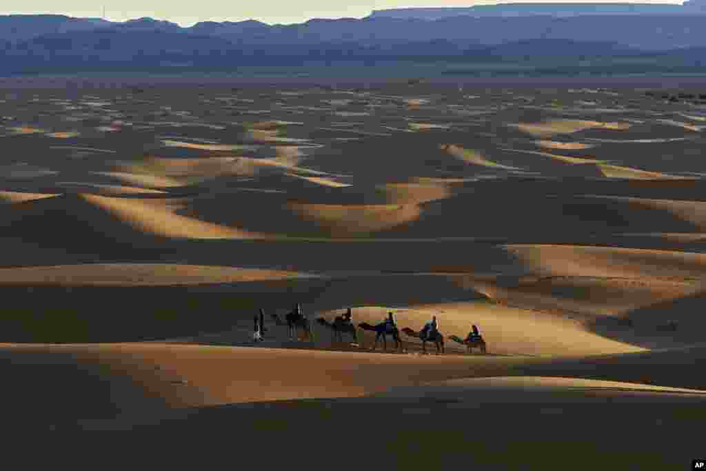 Tourists ride camels in Merzouga, Morocco along what is called the route of a thousand kasbahs in the Atlas Mountains, March 5, 2017.