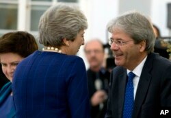 British Prime Minister Theresa May, left, speaks with Italian Prime Minister Paolo Gentiloni during an informal dinner ahead of an EU Digital Summit in Tallinn, Estonia, Sept. 28, 2017.