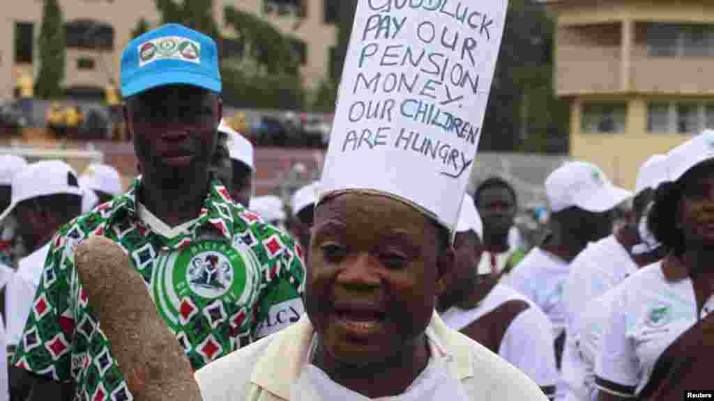 A worker holding a yam tuber with slogans on his clothes, protests during a parade marking Workers' Day in Nigeria, May 1, 2013.