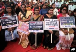 India's main opposition Congress party workers hold placards during a protest on the first anniversary of the Nov. 8 demonetization announcement, in Mumbai, India, Wednesday, Nov. 8, 2017.