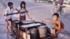 Cambodian children transfer water to their home in Phnom Penh, Cambodia, file photo from 1980's. (Courtesy of John Burgess)
