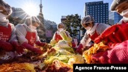 Participants prepare kimchi, a traditional Korean dish of spicy fermented cabbage and radish, during a kimchi making festival at the Jogyesa Buddhist temple in Seoul on December 2, 2021, before it is distributed among the less privileged from the local ne