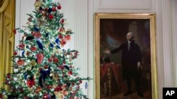 Un árbol decorado se encuentra junto al retrato del presidente George Washington en la Sala Este durante la vista previa de Navidad de 2019 en la Casa Blanca, el lunes 2 de diciembre de 2019, en Washington. (Foto AP / Alex Brandon).
