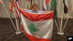 FILE - This Sept. 30, 2018 photo provided by Rochana Atmeh, shows Jennifer Maria Hektor, 8, born to a Swedish father and Rochana Atmeh, her Lebanese mother, holding a Lebanese flag, in Johannesburg, South Africa. 