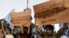FILE - Activists of Pakistan's banned religious group Hizb-ut-Tahrir hold placards at an anti-U.S. rally in Karachi, Pakistan, April 1, 2012. 