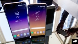 The Samsung Galaxy S8, right, and S8 Plus appear on display after a news conference, Wednesday, March 29, 2017, in New York. The Galaxy S8 features a larger display than its predecessor, the Galaxy S7, and sports a voice assistant intended to rival Siri and Google Assistant. (AP Photo/Mary Altaffer)