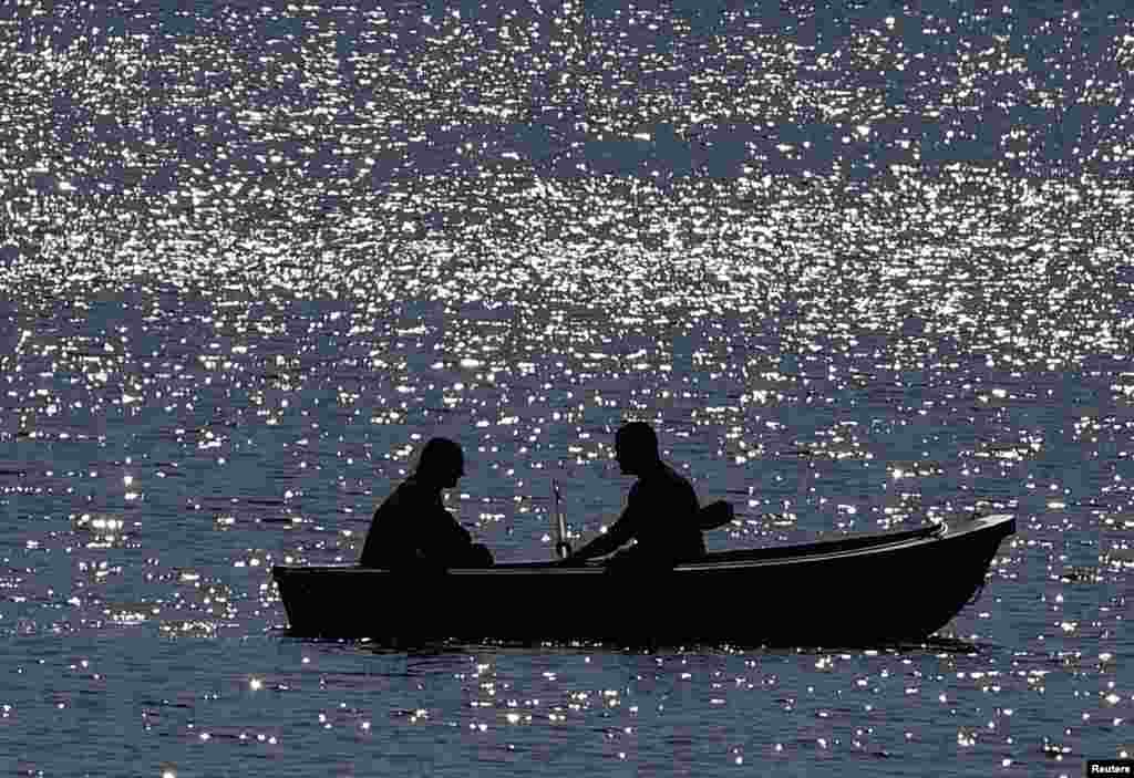 People row a boat on a lake in Gelsenkirchen, Germany.