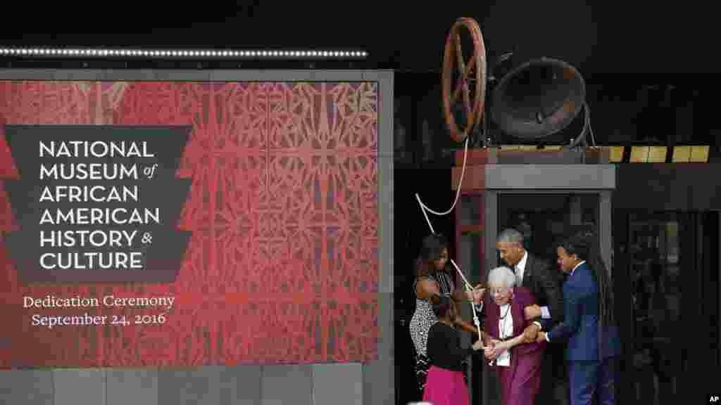 Le président Barack Obama et la première dame américaine Michelle Obama, sonnent la cloche de la liberté de la Première église de Williamsburg, avec les membres de la famille Bonner lors de la cérémonie d&#39;inauguration du Musée Smithsonian d&#39;histoire et de la culture afro-américaine au National Mall, à Washington DC, 24 septembre 2016. 