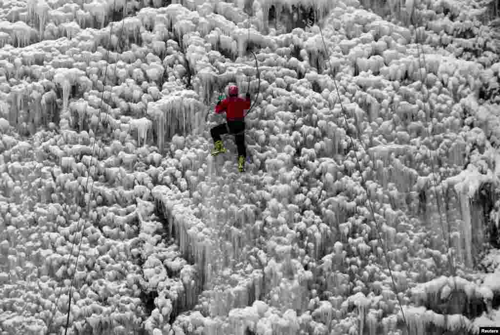 A man climbs an artificial wall of ice in the city of Liberec, Czech Republic, Jan. 23, 2016.