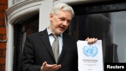 WikiLeaks founder Julian Assange holds a copy of a U.N. ruling as he makes a speech from the balcony of the Ecuadorian Embassy, in central London, Britain, Feb. 5, 2016. 