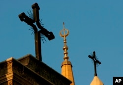 FILE - A minaret of the Mohammed al-Amin Mosque and two crosses on top of the Maronite St. George Cathedral are seen in downtown Beirut, Lebanon, Sept. 17, 2006.