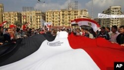 Egyptian anti-government demonstrators hold a huge national flag as they gather in Cairo's Tahrir square on February 9, 2011 on the 16th day of consecutive protests calling for the ouster of President Hosni Mubarak