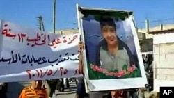 An image grab taken from YouTube on May 28, 2011, shows a Syrian man holding a picture of 13-year-old boy Hamza al-Khatib during his funeral on May 25, 2011 in the flashpoint region of Daraa, Syria