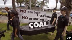 People walk with a coffin as they protest against the usage of coal during a climate change conference at the city of Durban, South Africa, December 1, 2011.