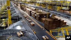 FILE - Packages ride on a conveyor system at an Amazon fulfillment center in Baltimore, Maryland, Aug. 3, 2017.