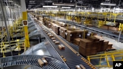 FILE - Packages ride on a conveyor system at an Amazon fulfillment center in Baltimore, Maryland, Aug. 3, 2017.
