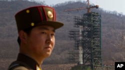 FILE - In this April 8, 2012 file photo, a North Korean soldier stands in front of the country's Unha-3 rocket at a launching site in Tongchang-ri, North Korea.