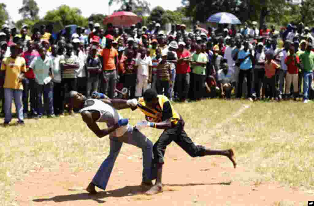 Fist fighters battle during the Musangwe, an age old tradition where men and boys display their fighting skills, at Gaba Village in Limpopo province December 22, 2011. The annual Venda fist-fighting run by community leaders, attracts hundreds of men who e