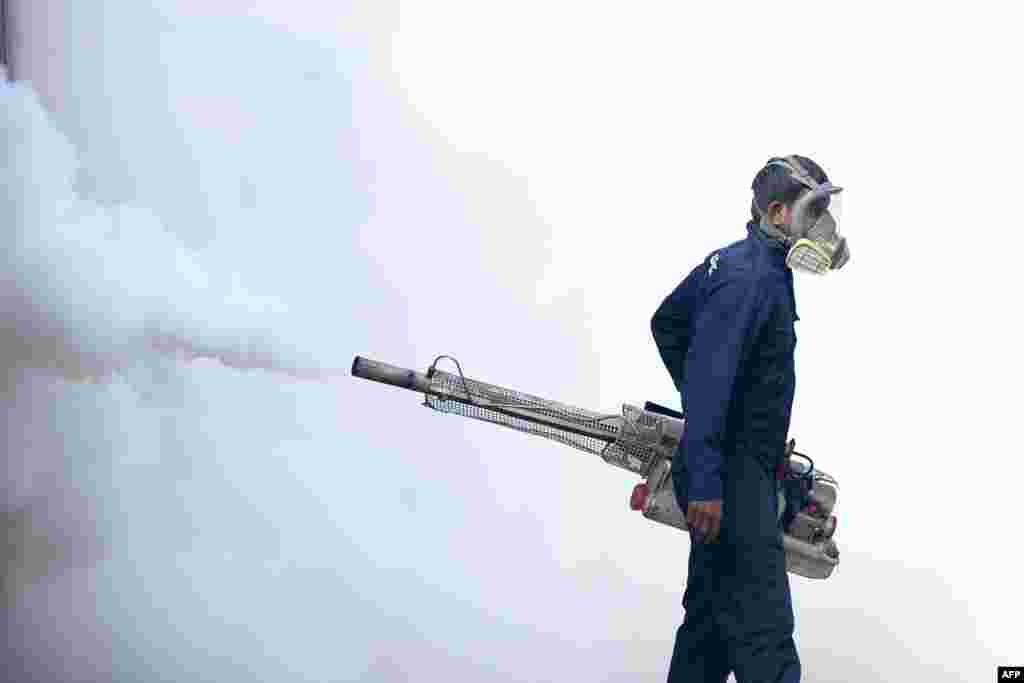 A municipal worker fumigates an area to kill mosquitos inside the Lumbini school in Colombo, Sri Lanka.