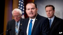 FILE - Sen. Mike Lee, R-Utah, with Sens. Bernie Sanders, I-Vt., left, and Chris Murphy, D-Conn., speaks in Washington, Jan. 30, 2019, on reintroduction of a resolution to end U.S. support for the war in Yemen. On May 2, 2019, the Senate failed to override a presidential veto.