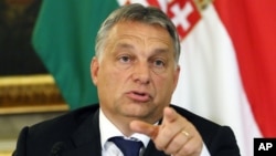 Hungarian Prime Minister Viktor Orban addresses the media on the occasion of a meeting with Austrian Chancellor Werner Faymann and Vice Chancellor Reinhold Mitterlehner at the Hungarian Embassy in Vienna, Austria, Sept. 25, 2015. 