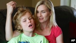 Colleen Jankovich looks over her 11-year-old autistic son, Matthew, who is non-verbal and requires 24/7 care, in Omaha, Nebraska, May 23, 2014.