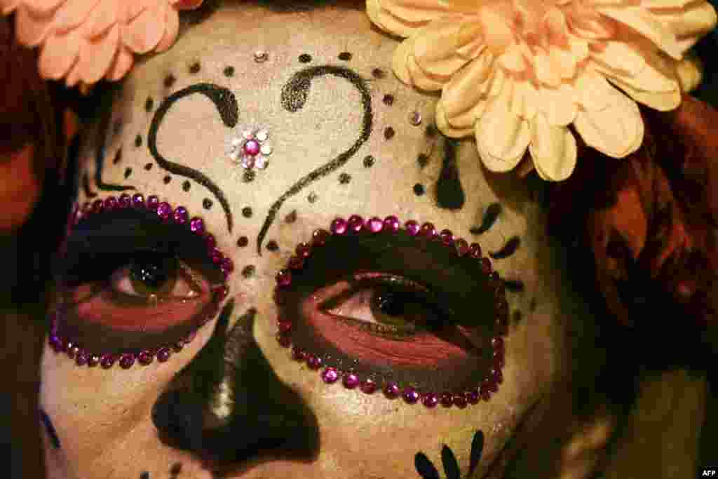 ស្រ្តី​ម្នាក់​តុបតែង​ជា La Calavera Catrina ចូលរួម​ក្នុង​ពិធី​ជប់លៀងMoto-Halloween នៅ​តាម​ផ្លូវ​ក្នុង​ក្រុង Cali ប្រទេស​កូឡុំប៊ី។