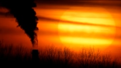 FILE - Emissions from a coal-fired power plant are silhouetted against the setting sun, Feb. 1, 2021, in Independence, Mo.