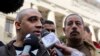 被囚禁的半岛电视台加拿大-埃及双重国籍记者穆罕默德•法赫米的兄弟阿德尔在开罗的一家法院前对媒体讲话。（2015年1月1日）