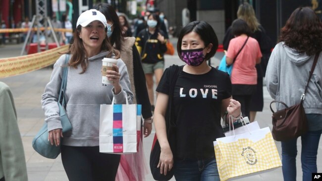 為防疫戴口罩的台灣民眾走過台北的購物街區。(2020年10月29日)