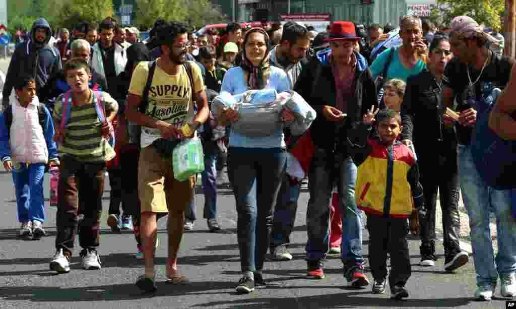 Migrantes and refugiados atravessam a fronteira entre a Hungria e a Áustria, junto a Nickelsdorf, Áustria, Set. 10, 2015.