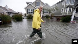 En la isla Fenwick, Delaware un hombre trata de ayudar a sus vecinos en medio de las primeras inundaciones a causa del huracán Sandy, el lunes. 