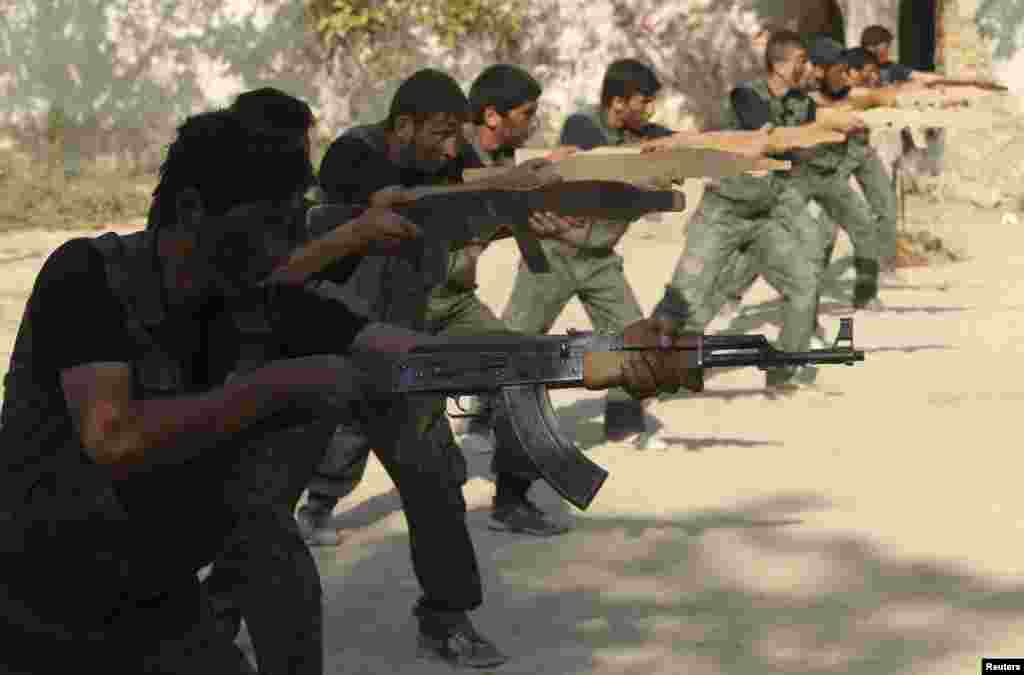 Rebel fighters perform a military display as part of a graduating ceremony at a camp in eastern al-Ghouta, near Damascus, Aug. 31, 2014.