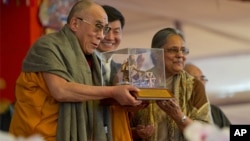 Tibetan spiritual leader the Dalai Lama receives the Mahatma Gandhi International Award for Reconciliation and Peace from Ela Gandhi, the granddaughter Mahatma Gandhi, as the Prime Minister of the Tibetan government-in-exile Lobsang Sangay, extreme right,