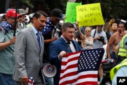 White nationalist Jason Kessler, center, walks to the White House to rally on the one year anniversary of the Charlottesville "Unite the Right" rally, Sunday, Aug. 12, 2018, in Washington.