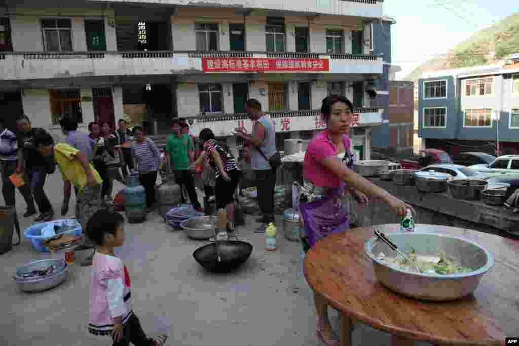 Residents gather to cook a meal in Yiliang, southwest China&#39;s Yunnan province following two shallow quakes that struck the remote and mountainous border area of Yunnan and Guizhou province of southwest China, Sept. 7, 2012.