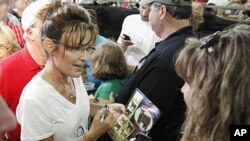 Former Alaska Governor Sarah Palin stops in the Cattle Tent as she visits at the Iowa State Fair in Des Moines, Iowa, August 12, 2011