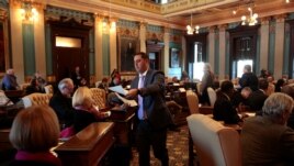 FILE - Ballots are passed out to 16 Electors on the Michigan Senate floor for them to cast their formal votes for the president and vice president of the United States in Lansing, Michigan, U.S., December 19, 2016