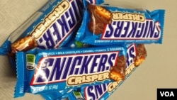 A display of chewy chocolate, caramel and peanuts Snickers bars. Confectionery maker Mars has issued a recall of its candy bars across Europe over fears that plastic pieces could be found inside. The recall covers 55 countries, Feb. 23, 2016. (D. Bekheet/VOA)