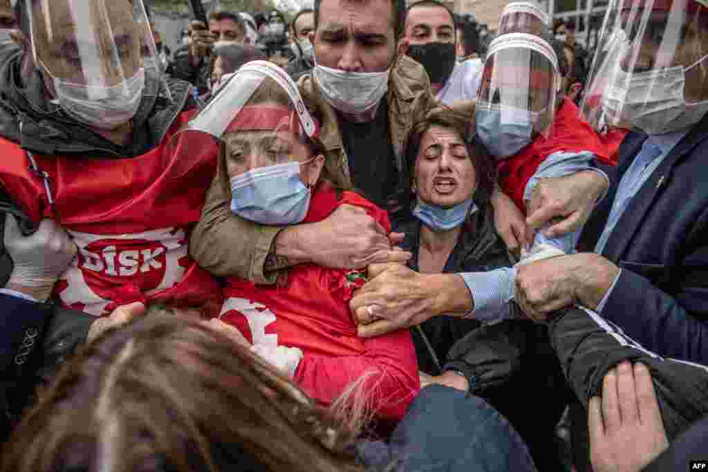 Demonstrators, wearing face masks for protection against the new coronavirus fight with Turkish police during a May Day rally marking the international day of the worker in Istanbul.