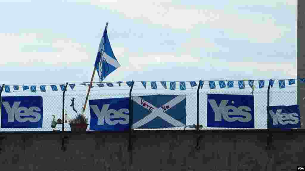 Vandals write on posters that proclaim support for Scotland's Independence near a block of flats in Leith, Edinburgh, Scotland, Sept. 16, 2014. (Marianne Brown/VOA)