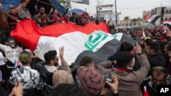 Para pedemo anti-pemerintah membawa bendera Irak dan meneriakkan slogan anti-Amerika di lapangan Tahrirm Baghdad, Irak, 10 Januari 2020.