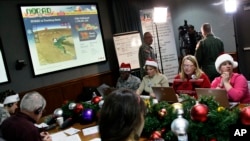 Volunteers take phone calls from children asking where Santa is and when he will deliver presents to their house, during the annual NORAD Tracks Santa Operation, at the North American Aerospace Defense Command, or NORAD, at Peterson Air Force Base.