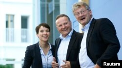 Berlin top candidate of the anti-immigration party Alternative for Germany (AfD) Georg Pazderski (C) and AfD Germany co-leaders Joerg Meuthen (R) and Frauke Petri (L) arrive for their news conference at the Bundespressekonferenz in Berlin, Sept. 19, 2016.