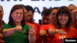 FILE - Davao City Mayor Sara Duterte-Carpio (L) and Ilocos Norte Governor Imee Marcos gestures during an alliance meeting with local political parties in Paranaque, Metro Manila in Philippines, Aug. 13, 2018. 