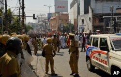 Policemen stand guard during a march by Bharatiya Janata Party activists as part of a strike call by Sabarimala Karma Samithi, an umbrella organization of Hindu groups, in Thiruvananthapuram, capital of the southern Indian state of Kerala, Jan. 3, 2019.