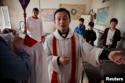 Father Ju Ruibin of the government-sanctioned Catholic church prepares for the procession on Palm Sunday in Youtong village, Hebei province, China, March 25, 2018.