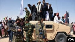 Kombatan Taliban merayakan gencatan senjata pada hari ketiga Idul Fitri di distrik Maiwand, Provinsi Kandahar, Afghanistan, 17 Juni 2018. 